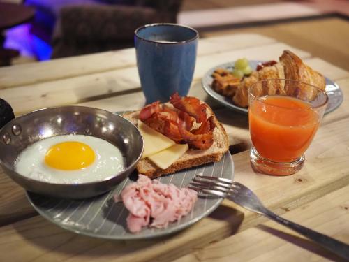 a breakfast plate of eggs and toast and a glass of orange juice at JOST Hostel Lille Centre in Lille