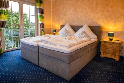 a large bed in a room with a large window at Hotel Restaurant Narasinga in Wassenberg