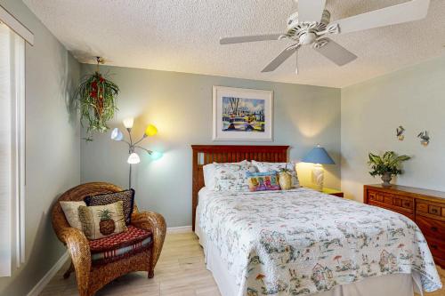 a bedroom with a bed and a chair and a ceiling fan at Paradise Found in Bradenton