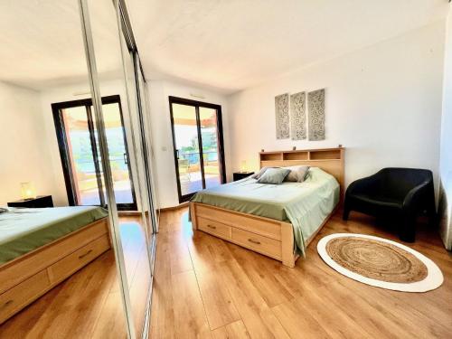 - une chambre avec 2 lits et une chaise dans l'établissement ApartHotel Riviera - Terrasse de Fabron - Swimming pool - Sea View, à Nice