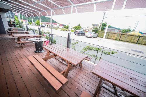 a group of benches sitting on a wooden deck at Pohang Rainbow Pension in Pohang