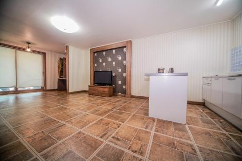 a large room with a large tile floor and a tv at Pohang Rainbow Pension in Pohang