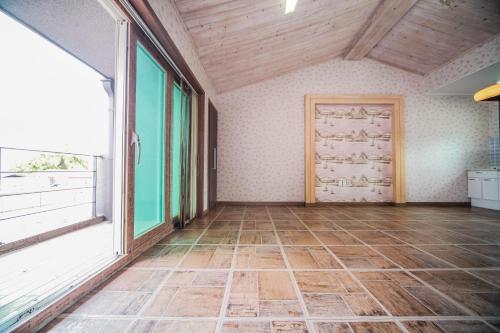 an empty room with a large window and a door at Pohang Rainbow Pension in Pohang