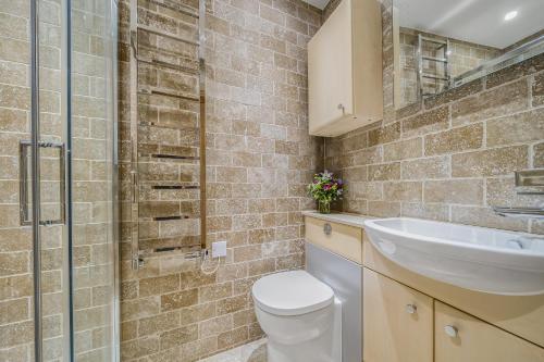 a bathroom with a toilet and a sink and a shower at No 16 The Salcombe in Salcombe