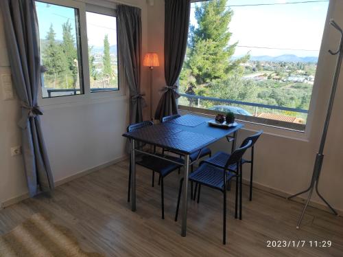 ein Esszimmer mit Tisch und Stühlen und einem Fenster in der Unterkunft Agriliki Cottage - Amazing View & Nature Escape in Vraná