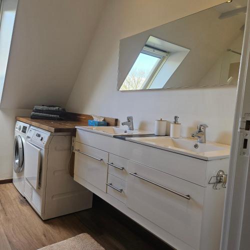 a bathroom with a sink and a washing machine at Delicateske in Meppen