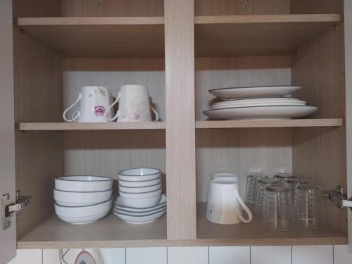 a cupboard with plates and bowls and dishes in it at Danyang mulgoeul pension in Danyang