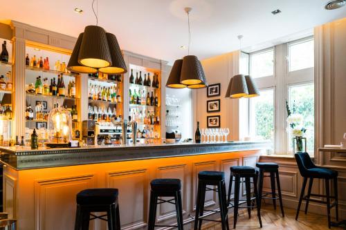 a bar with black stools in a room at Maison D'Anthouard in Écully