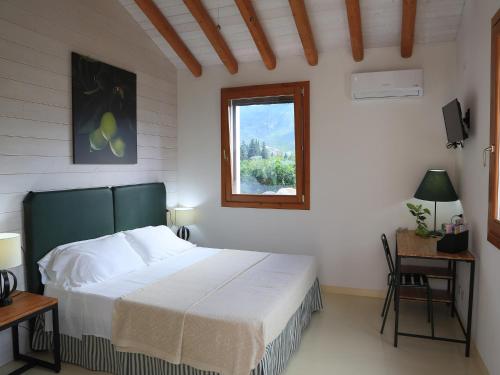 a bedroom with a large bed and a window at Luna&Limoni Country in Muravera
