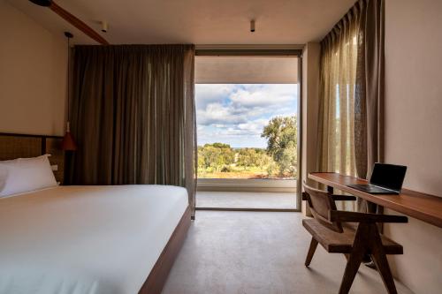 a bedroom with a bed and a desk with a laptop at Botanico Villa & Suites in Specchiolla 