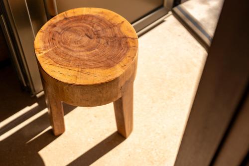 a wooden stool sitting in front of a window at Botanico Villa & Suites in Specchiolla 
