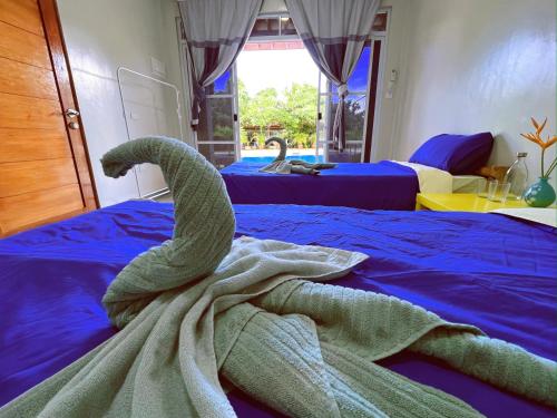 a towel on a bed in a bedroom with two beds at Diver Inn in Panglao