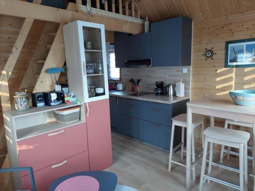 cocina con nevera rosa y mesa en Le petit Bachelet - Chalet tout confort à la mer, en Plérin