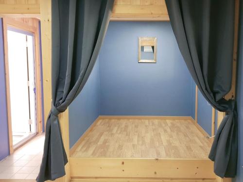 a bedroom with blue walls and a curtain at Cheongju Okhwadaestory Pension in Cheongju