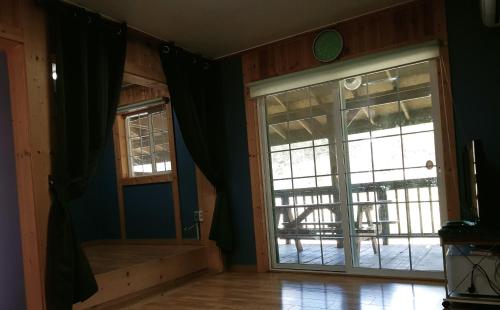 a living room with a sliding glass door at Cheongju Okhwadaestory Pension in Cheongju