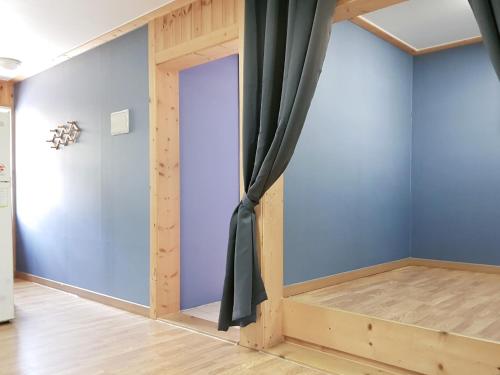 a room with blue walls and a curtain at Cheongju Okhwadaestory Pension in Cheongju