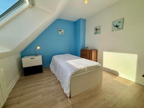 une chambre avec un lit avec un mur bleu dans l'établissement Maison familiale 5P, proche plage, quartier Port Haliguen, terrasse sud-ouest, parking, WIFI inclus - FR-1-478-238, à Quiberon