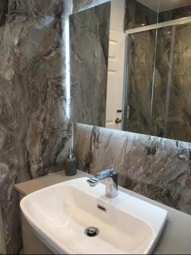 a bathroom with a sink and a mirror at Duke's House, Penrith - Stunning Large Home - Town Centre on your Doorstep - 5 Bedrooms & Sun Trap Garden - Lake District Stay in Penrith