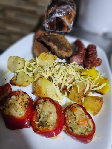a white plate of food with tomatoes and other foods at Pensiunea Miruna in Moieciu de Jos