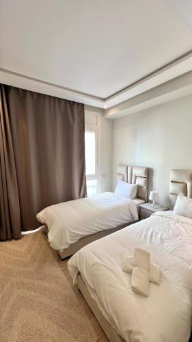a bedroom with two beds and a window at N28 Rabat Corniche Appartement Moderne à Deux Pas de la Mer in Rabat
