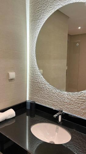 a bathroom with a sink and a large mirror at N28 Rabat Corniche Appartement Moderne à Deux Pas de la Mer in Rabat