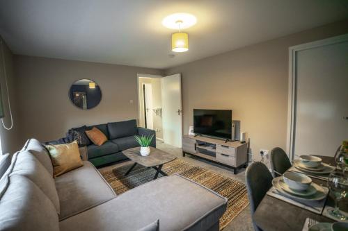 een woonkamer met een bank en een tv bij 2 BDR Flat By Caledonia Luxe Stays Short Lets & Serviced Accommodation Coatbridge in Coatbridge