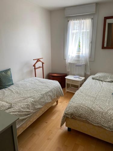 une chambre avec deux lits et une fenêtre dans l'établissement Appartement 3 pièces cœur Riva Bella, à Ouistreham
