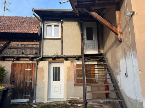 a house with a staircase leading up to a door at Douceur in Herrlisheim
