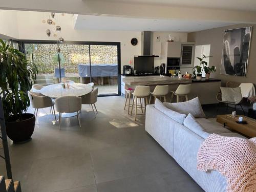 un salon avec un canapé et une table et une cuisine dans l'établissement Villa Spacieuse avec Spa - Calme et Proche Plage, Lac et Golfs - FR-1-791-3, à Soorts-Hossegor