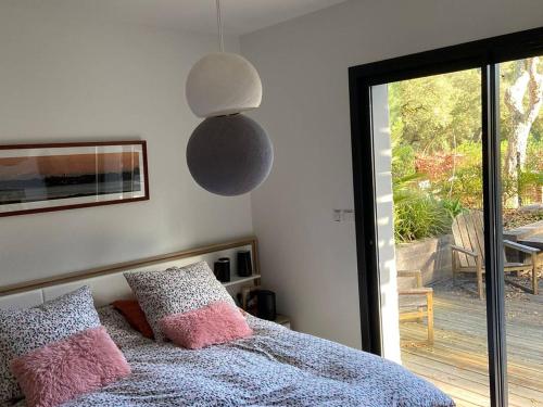 une chambre avec un lit et une porte coulissante en verre dans l'établissement Villa Spacieuse avec Spa - Calme et Proche Plage, Lac et Golfs - FR-1-791-3, à Soorts-Hossegor