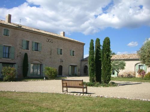 un banc assis devant un bâtiment dans l'établissement Studio charmant au cœur de Valensole avec accès piscine - FR-1-822-1, à Brunet