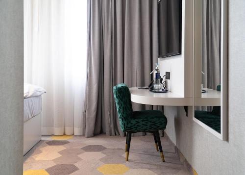 a bathroom with a table and a green chair at Olive INN Berlin in Berlin