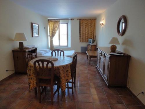 un salon avec une table et des chaises et une chambre dans l'établissement Studio charmant au cœur de Valensole avec accès piscine - FR-1-822-1, à Brunet