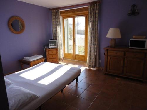 une chambre avec un grand lit et une fenêtre dans l'établissement Studio familial paisible avec piscine au cœur de Valensole - FR-1-822-3, à Brunet