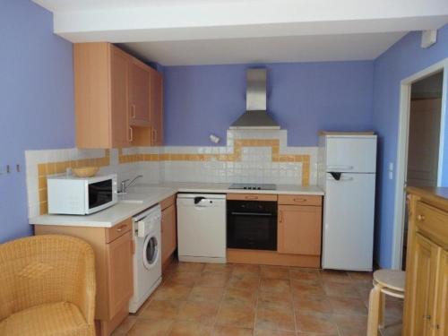 La cuisine est équipée d'un réfrigérateur blanc et d'un four micro-ondes. dans l'établissement Appartement confortable avec piscine au cœur du plateau de Valensole - FR-1-822-6, à Brunet