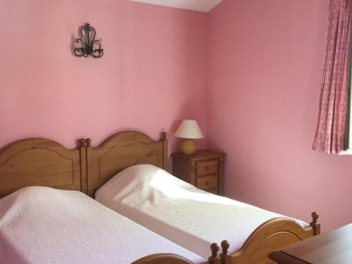 - une chambre aux murs roses avec un lit et une lampe dans l'établissement Gîte familial confortable au cœur de Valensole - FR-1-822-8, à Brunet