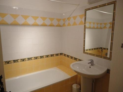 une salle de bain avec un lavabo, une baignoire et un miroir dans l'établissement Appartement spacieux au coeur de Valensole avec piscine - FR-1-822-11, à Brunet
