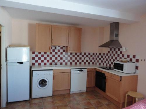 La cuisine est équipée d'un réfrigérateur blanc et d'un lave-vaisselle. dans l'établissement Gîte au coeur du plateau de Valensole avec piscine - FR-1-822-9, à Brunet