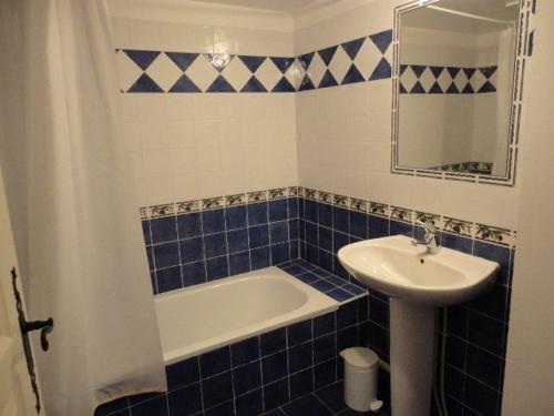 La salle de bains est pourvue de carrelage bleu, d'un lavabo et d'une baignoire. dans l'établissement Gîte au coeur du plateau de Valensole avec piscine - FR-1-822-9, à Brunet