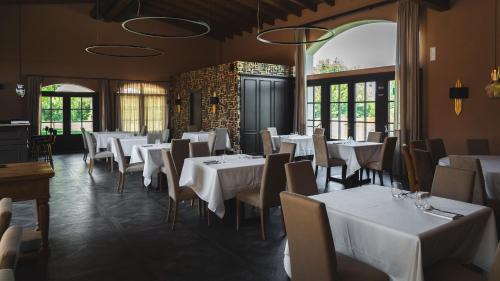 a dining room with white tables and chairs at Alle Siepi in Reggio Emilia