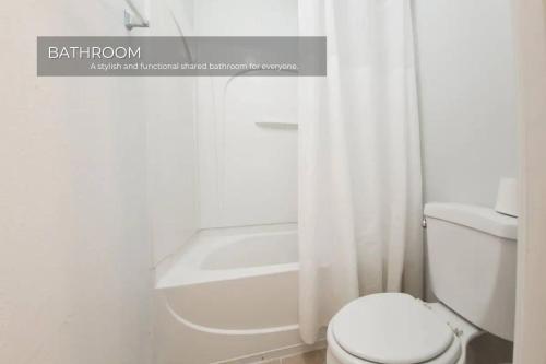 une salle de bain blanche avec toilettes et douche dans l'établissement Stunning 3BD Condo 14 Mins to Disney World , Gated, à Kissimmee