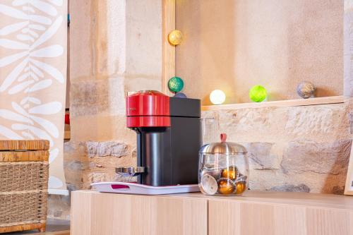 a coffee maker on a counter with fruit in a jar at À La Motte Cinema, Park BY PRIMO C0NCIERGERIE in Cuisery
