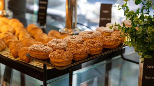 a display case filled with different types of donuts at The Abdali Boulevard Hotel in Amman