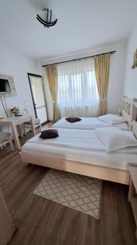 a large bedroom with two large beds in it at Dor de Casa in Doljeşti