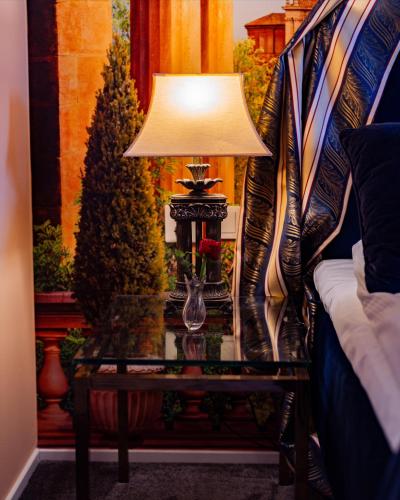 a lamp on a table next to a christmas tree at Slottsgården Hotell & Restaurang in Vadstena
