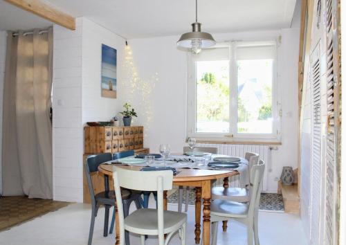 une salle à manger avec une table et des chaises en bois dans l'établissement La Maison de la Plage-100m Plage du Casino, à Saint-Quay-Portrieux