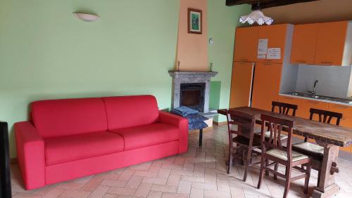 a living room with a red couch and a table at Casa Angelino in Cannobio