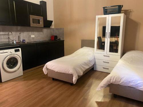 a bedroom with two beds and a washing machine at Rotterdam Inn in Rotterdam