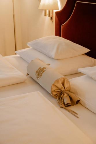 a bow on a bed with white sheets and pillows at Hotel Erzherzog Rainer in Vienna
