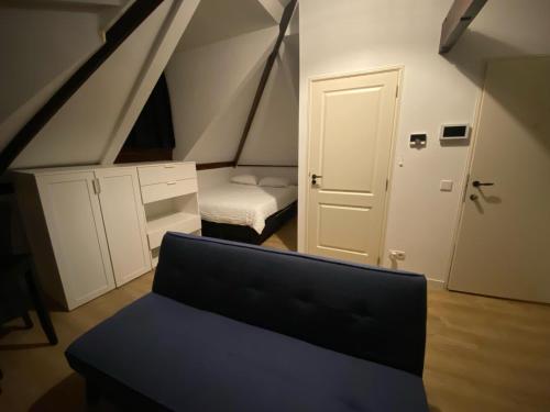 a small attic room with a bed and a door at Rotterdam Inn in Rotterdam